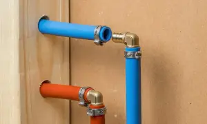 Połączenie rur pcv bez kielicha, z użyciem metalowych obejm i złączek kątowych. Instalacja wodna w trakcie montażu.