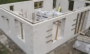 Budowa domu z bloczków SOLBET – najtańszy materiał na ściany. Widać zbrojenie i przygotowane otwory okienne.