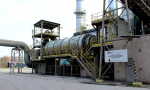 Przemysłowa instalacja, gdzie skała osadowa do wyrobu cementu jest przetwarzana. Widoczny piec obrotowy i rurociągi.