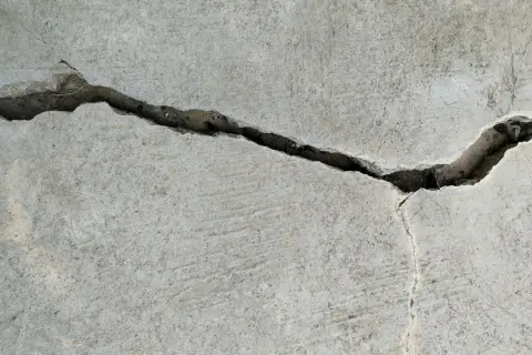 Pęknięcie w betonie, gdzie widać drobne włókno polimerowe wzmacniające strukturę.