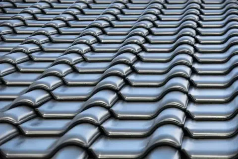 Szare dachówki ceramiczne tworzą falisty wzór na dachu. Ich waga zapewnia stabilność konstrukcji.