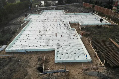 Płyta fundamentowa na glinie, przygotowana do wylania betonu. Widać zbrojenie i izolację.