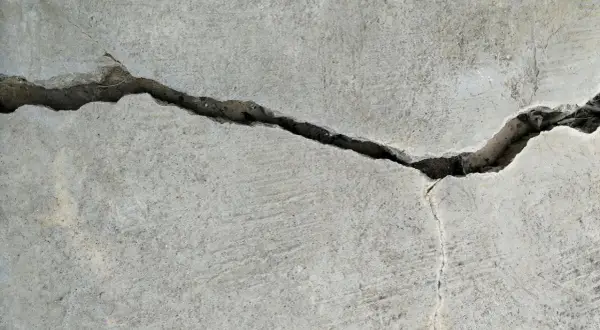 Pęknięcie w betonie, gdzie widać drobne włókno polimerowe wzmacniające strukturę.