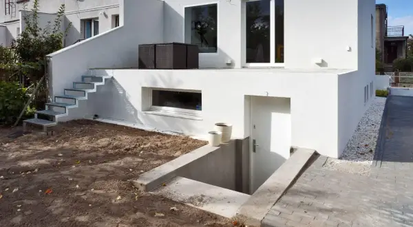 Nowe zejście do piwnicy na zewnątrz, z betonowymi schodkami i metalowymi stopniami prowadzącymi do drzwi.