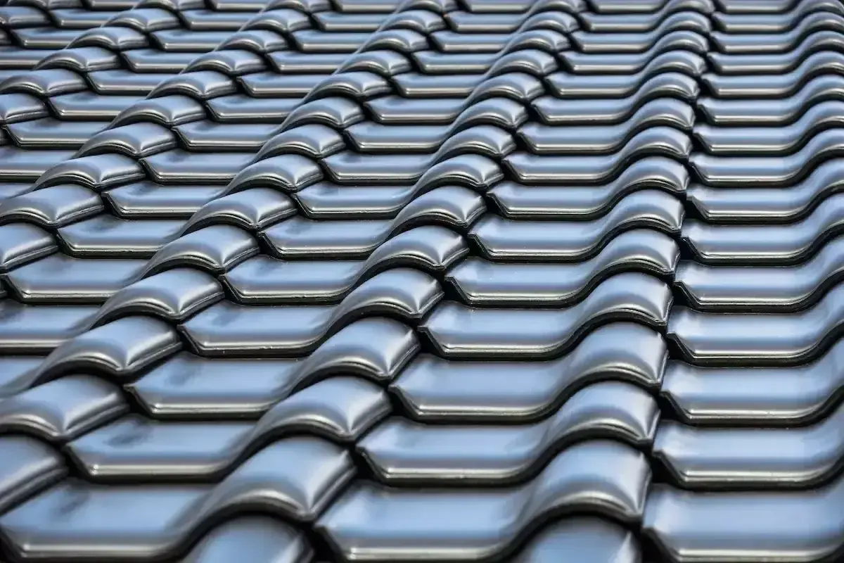 Szare dachówki ceramiczne tworzą falisty wzór na dachu. Ich waga zapewnia stabilność konstrukcji.