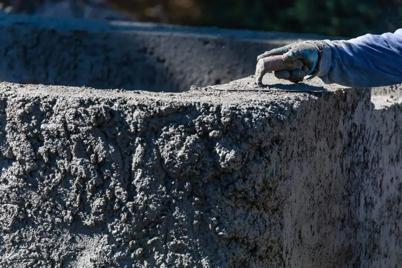 Ręka w rękawicy wygładza świeży beton C30/37. Sprawdź aktualną beton c30/37 cena.