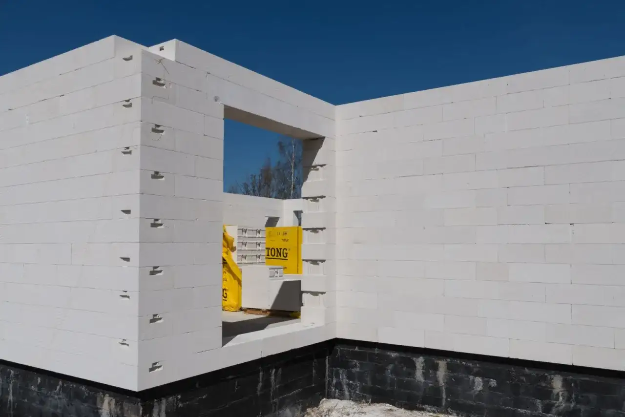 Budowa domu z bloczków Ytong. Widać żółte opakowania materiałów budowlanych, które mogą być pomocne przy sprawdzaniu ytong cennik.