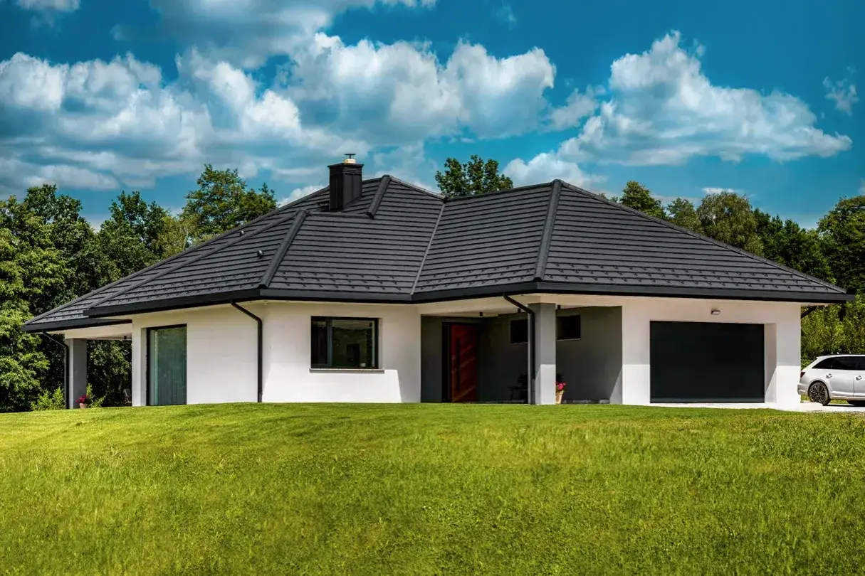 Nowoczesny dom z ciemnym dachem z dachówki ceramicznej. Waga dachówki ceramicznej zapewnia trwałość i estetykę.