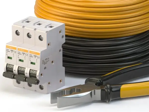 Wyłączniki nadprądowe, zwój żółtego i czarnego kabla oraz kombinerki. Idealne do instalacji, jaki kabel od skrzynki do domu 14kW?