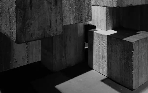 Betonowe bloki tworzą abstrakcyjną kompozycję, gdzie światło i cień rzeźbią formy. To jakby fragmenty miasta, które w tej chwili są tylko cem iii.