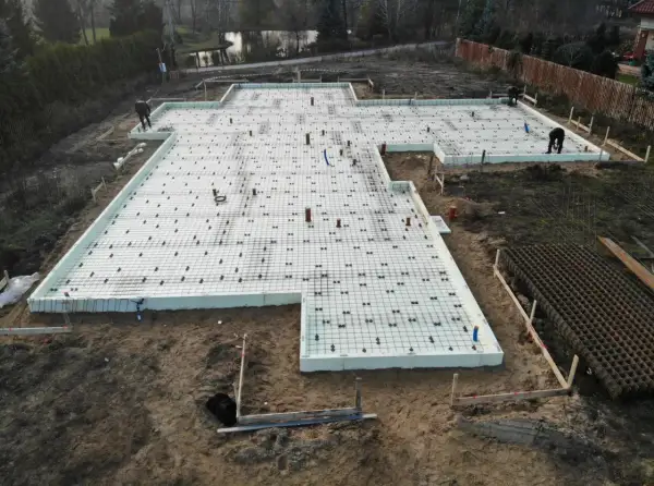 Płyta fundamentowa na glinie, przygotowana do wylania betonu. Widać zbrojenie i izolację.